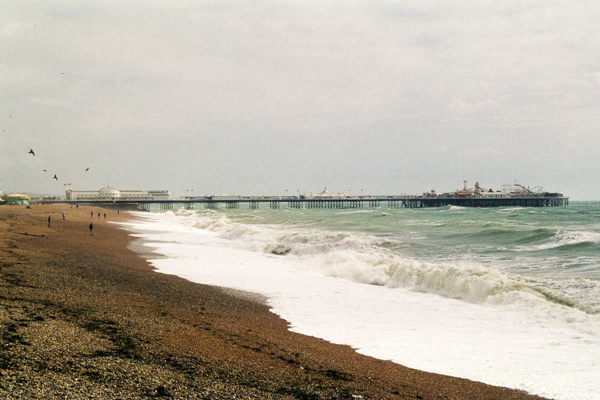 A wide-angle view of Brighton West Pier in 1999, showing the front pavilion and rear concert hall standing above the sea