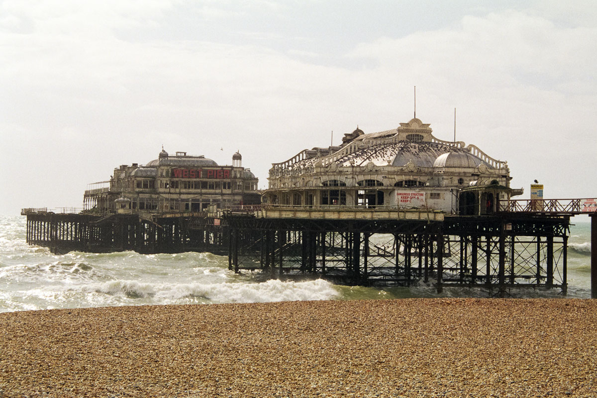 West Pier in 1999, intact but weathered, with its entrance sign visible, capturing the pier's faded elegance before the 2003 fires