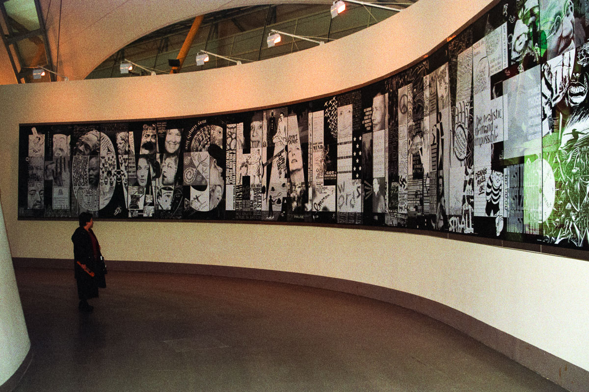 A woman reads the "How Shall I Live?" display in the Faith Zone