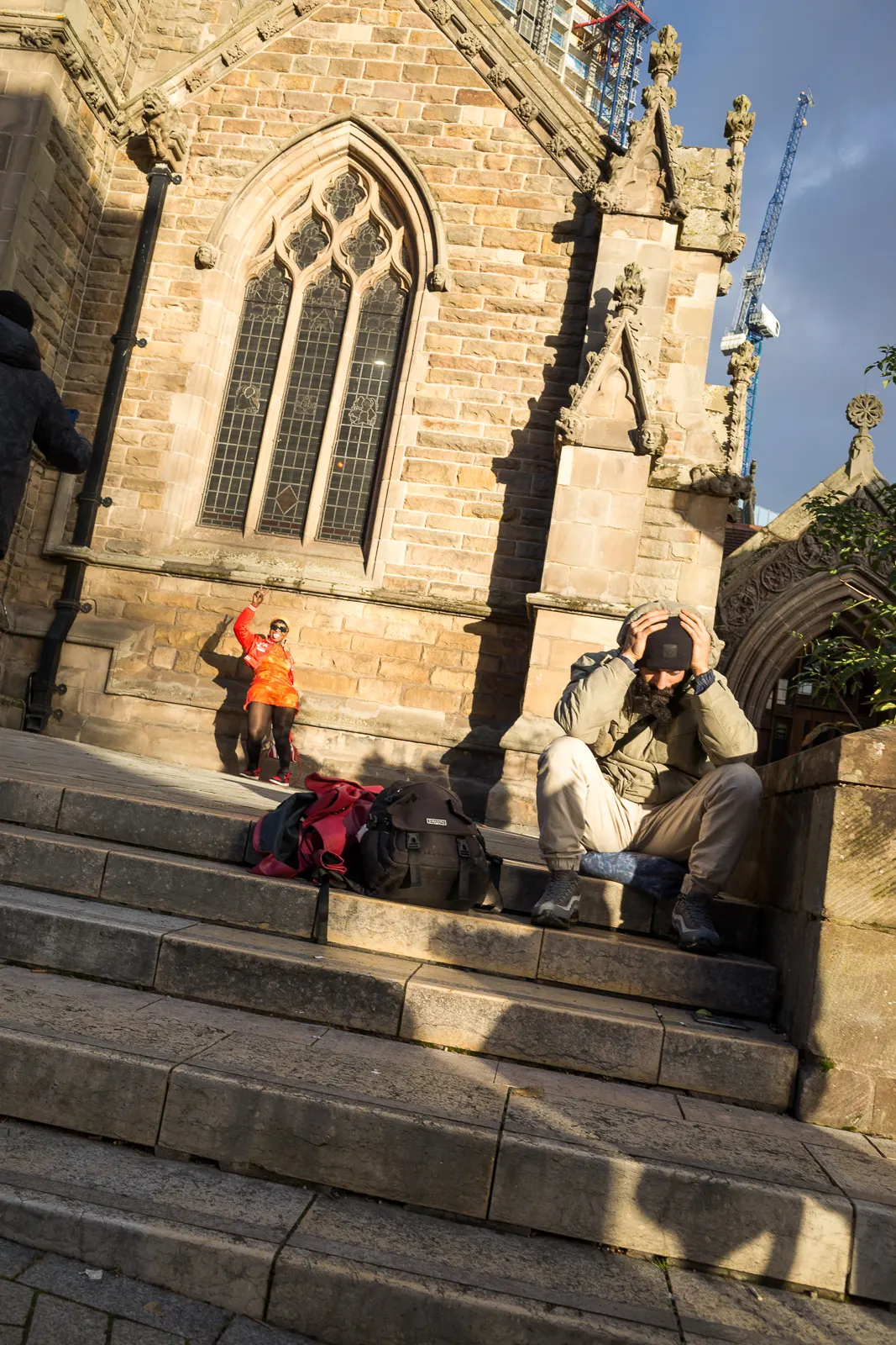 A decisive moment: a woman poses for photographs while a man rests on the steps of St. Martin's Church