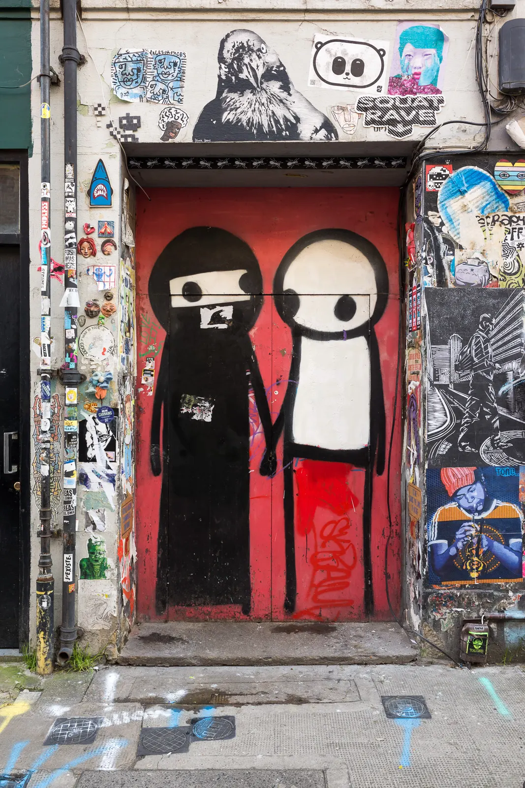 A Stik mural of a woman wearing a niqab holding hands with another stick-figure character