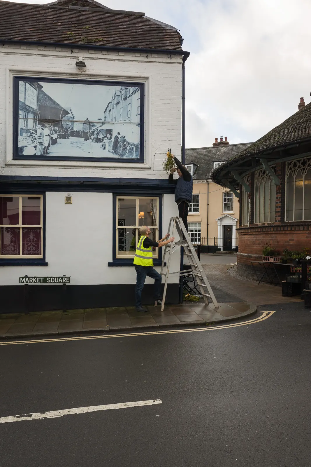 Locals hang mistletoe outside shops during Tenbury Mistletoe Festival