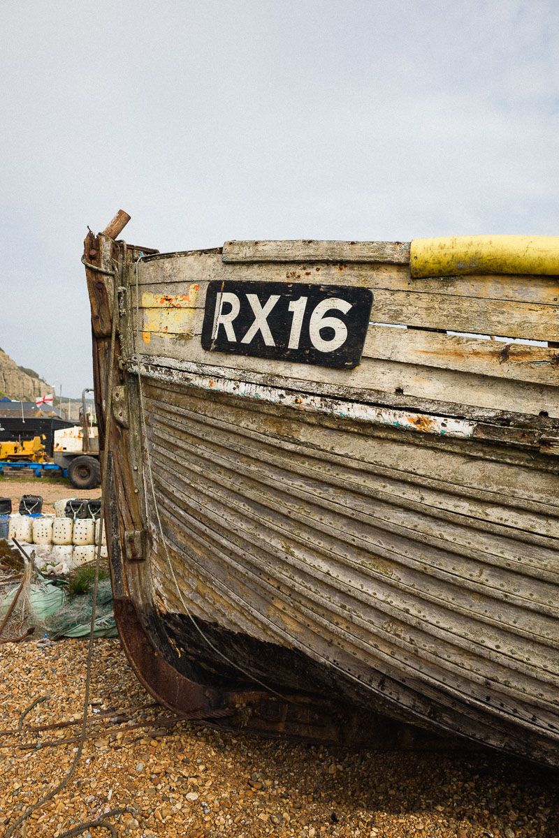 An old wooden fishing boat, RX16, weathered on Hastings Beach