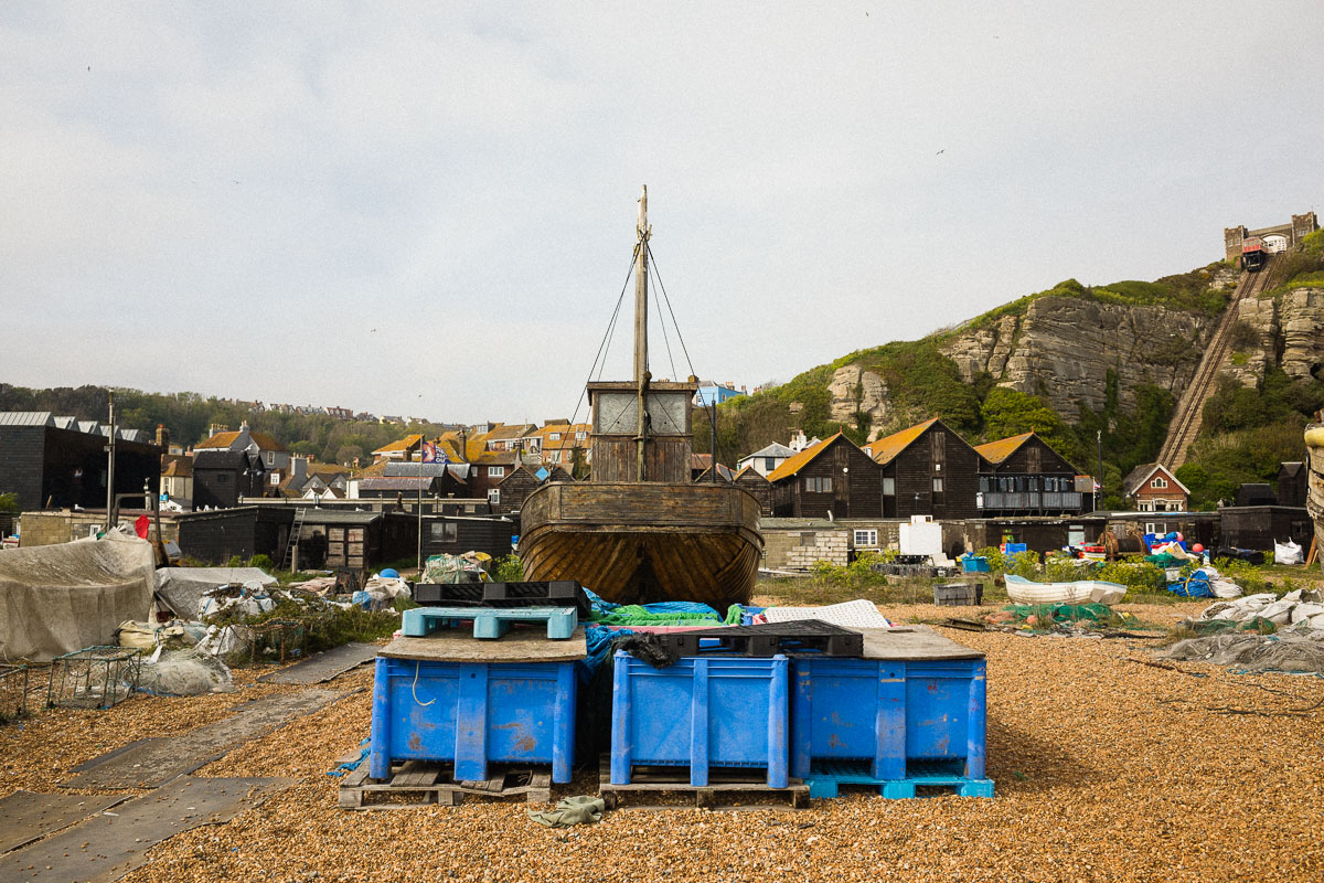 A weathered wooden fishing boat on the working part of Hastings Beach
