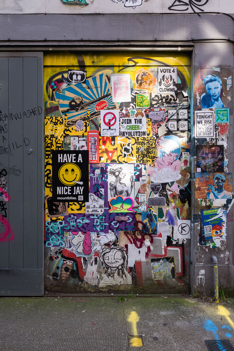 Graffiti and street art overlap on a wall in Brick Lane