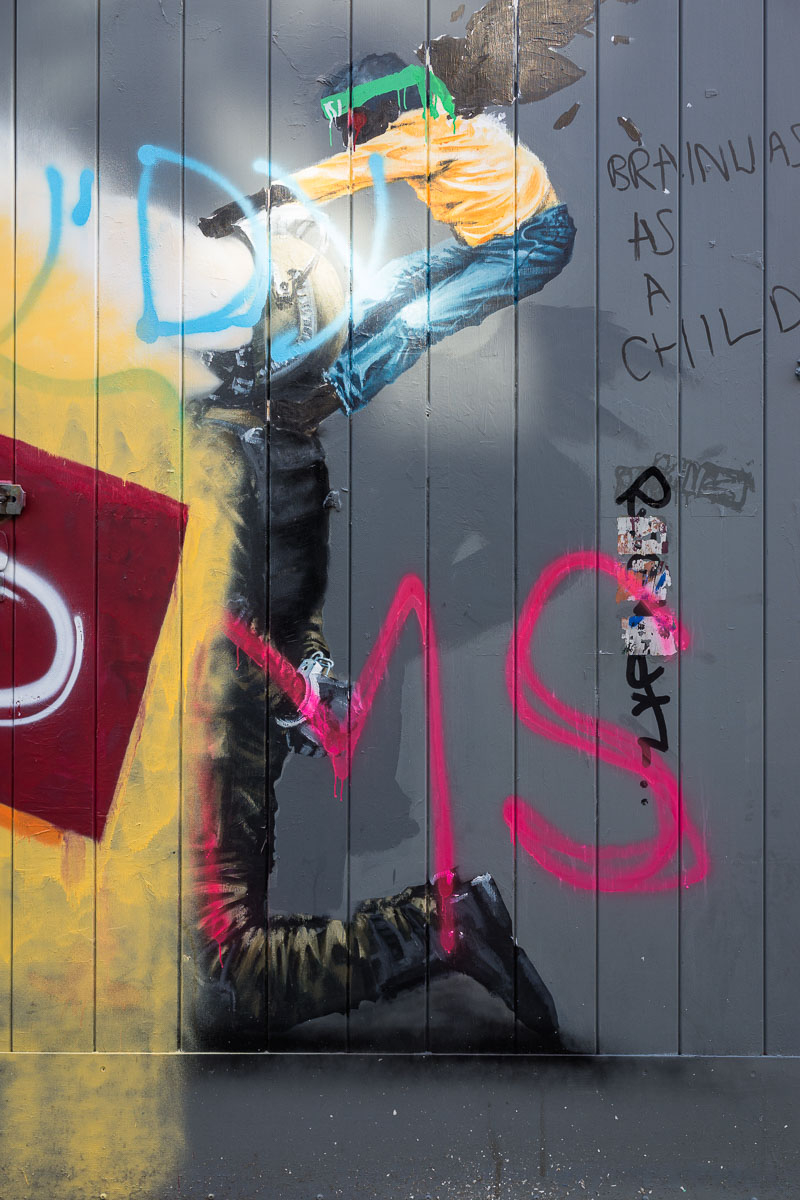 A damaged mural by Palestinian artist Taqi Spateen depicting a handcuffed fighter pilot holding a winged child