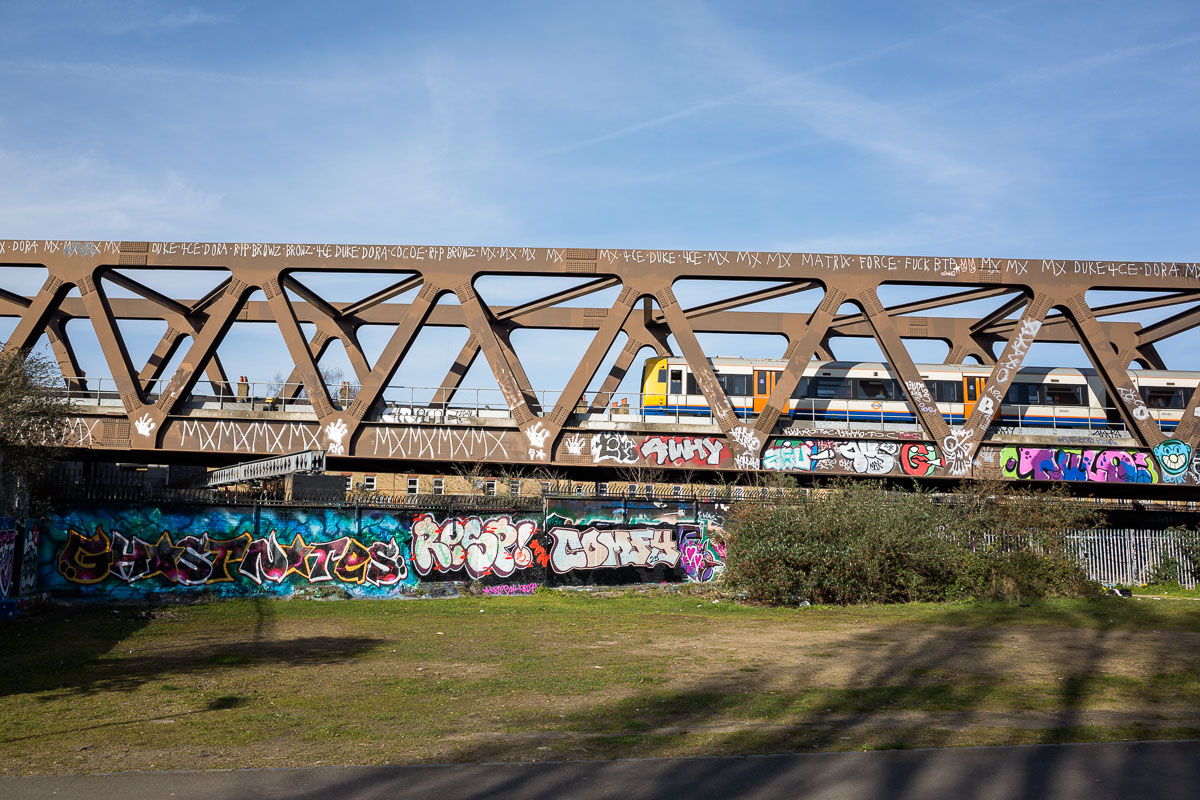 Graffiti and street art cover the Overground train bridge