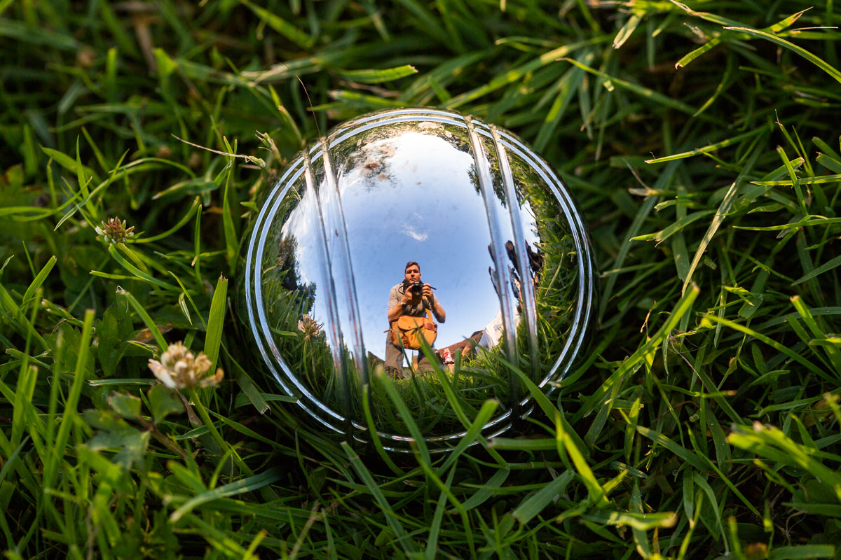 A selfie reflected in a shiny croquet ball, capturing both scene and self