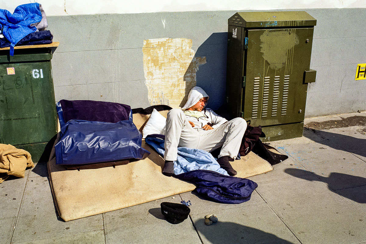 A person sleeping on the street highlights how sleep is a basic human need regardless of circumstance