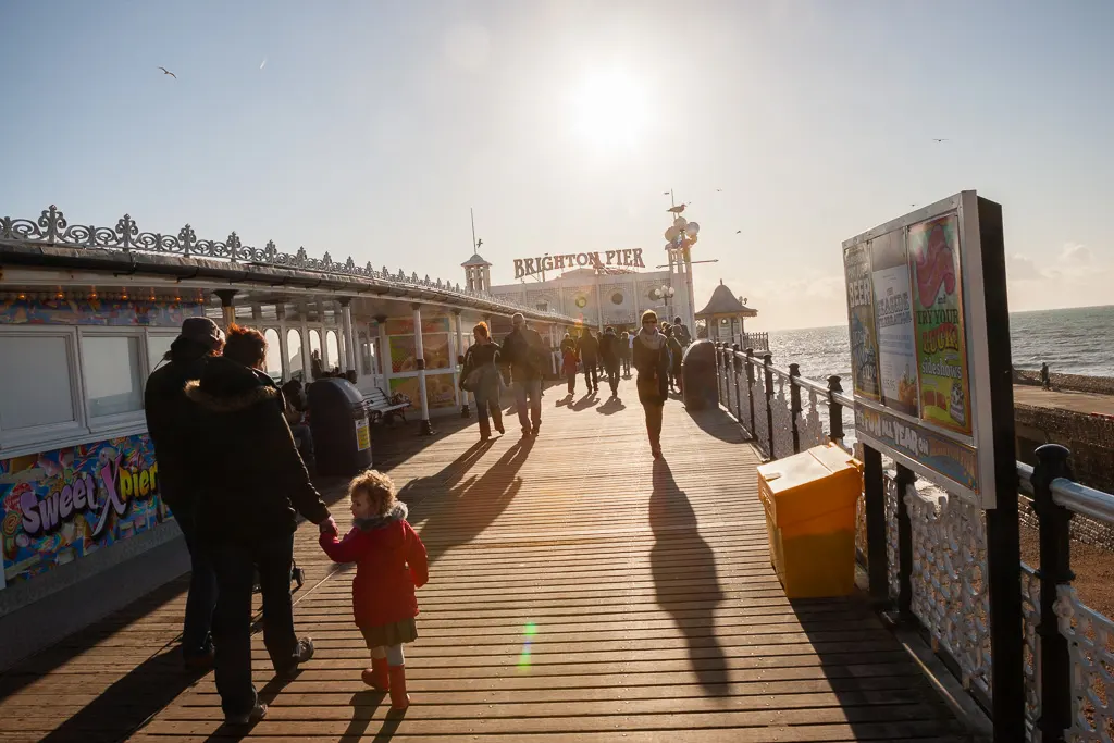 Visitors still enjoy walking along the lively promenade of Brighton Pier